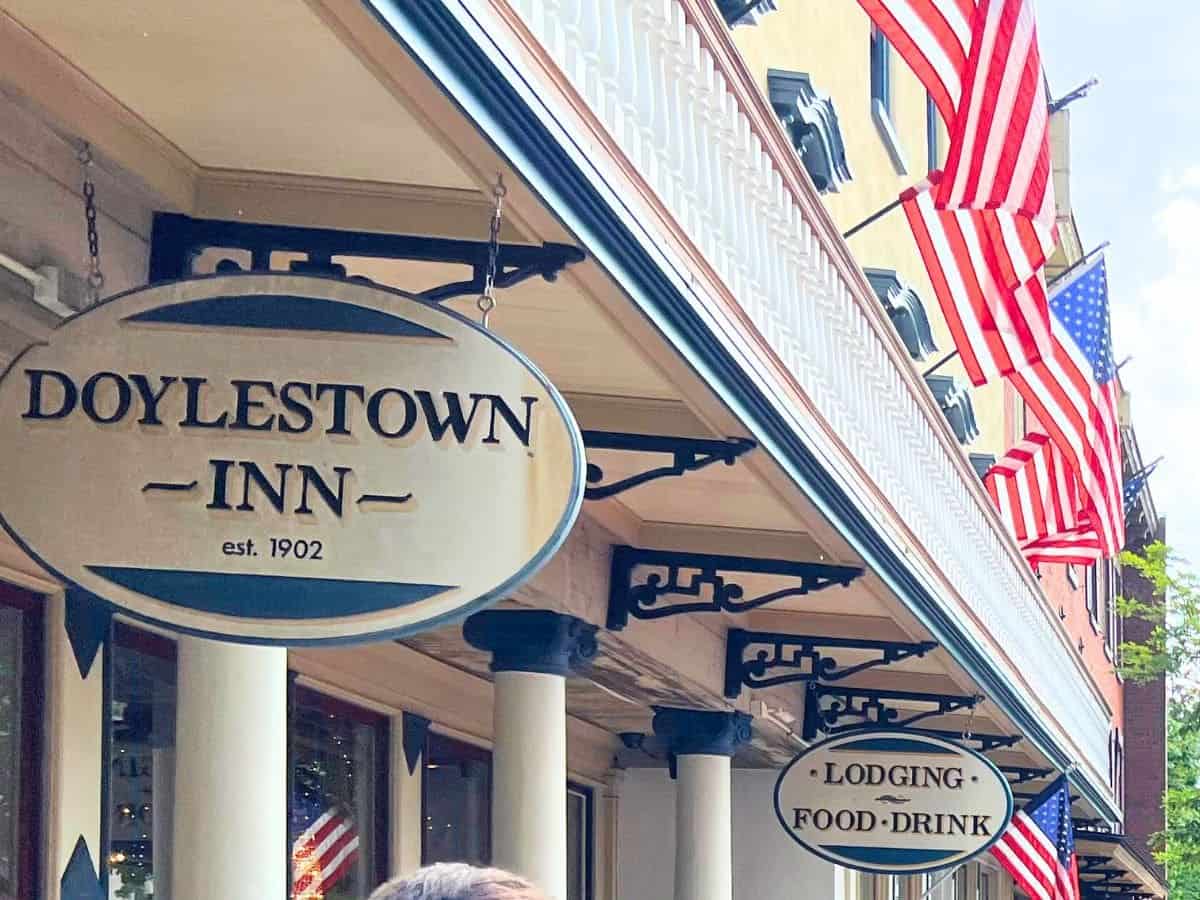 sign for doylestown inn with american flags hanging from the roof