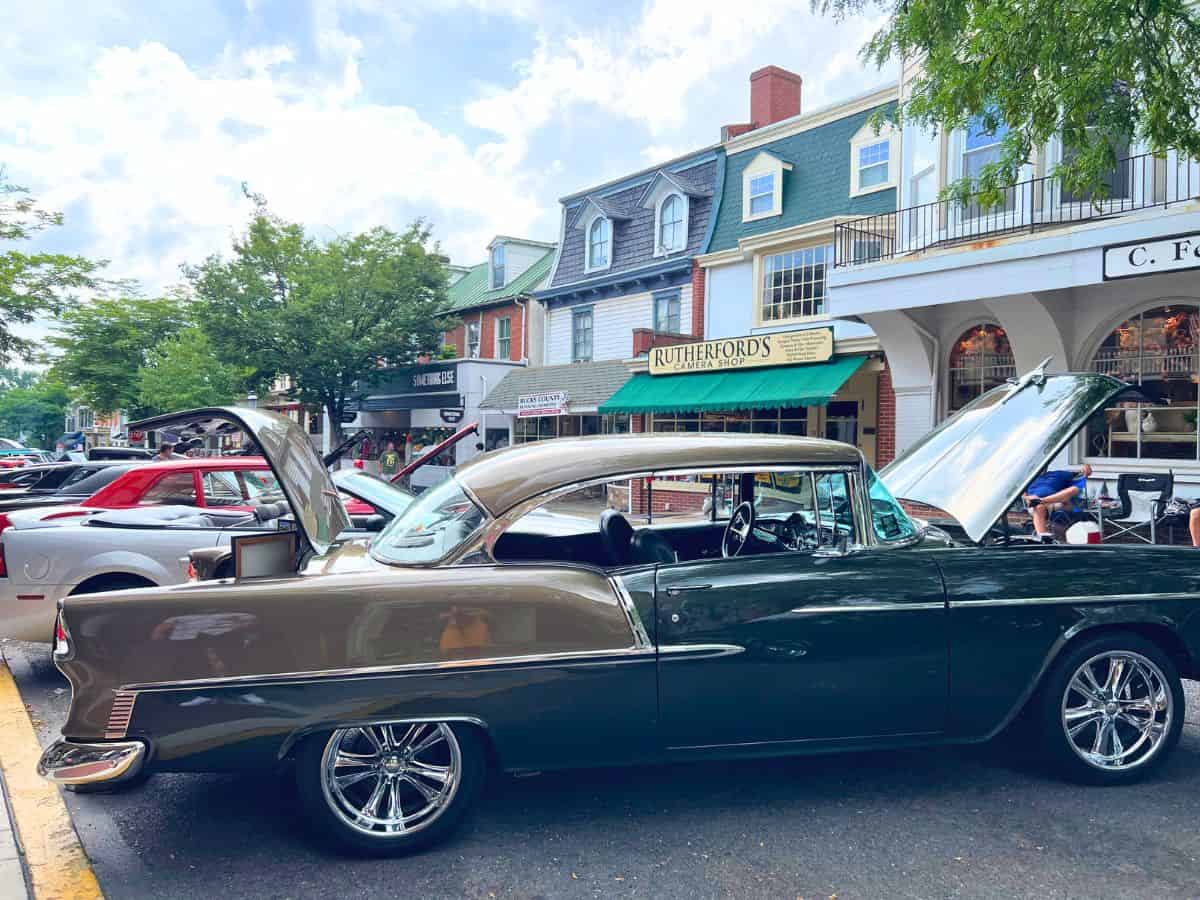 car show in doylestown pa. An old car is on the street with the hood up