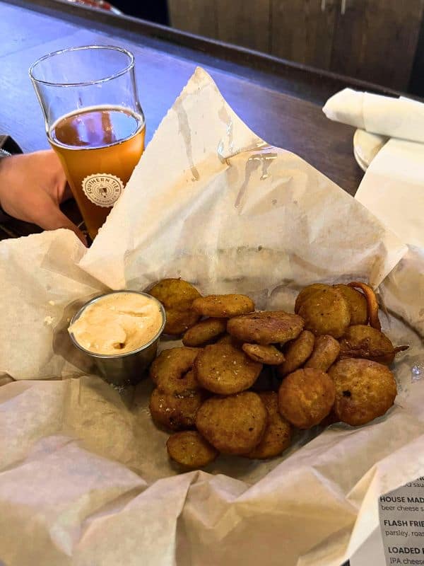 Fried pickles in a basket with a beer at a bar in Pittsburgh